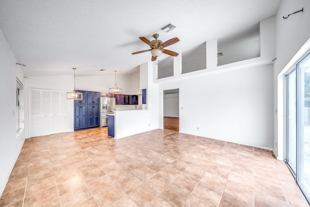 unfurnished living room with a textured ceiling, high vaulted ceiling, and ceiling fan