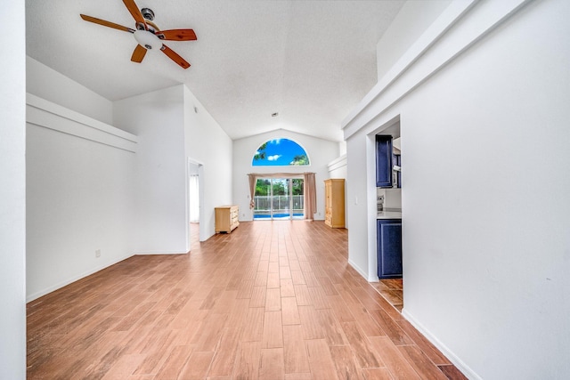 unfurnished living room with ceiling fan and high vaulted ceiling