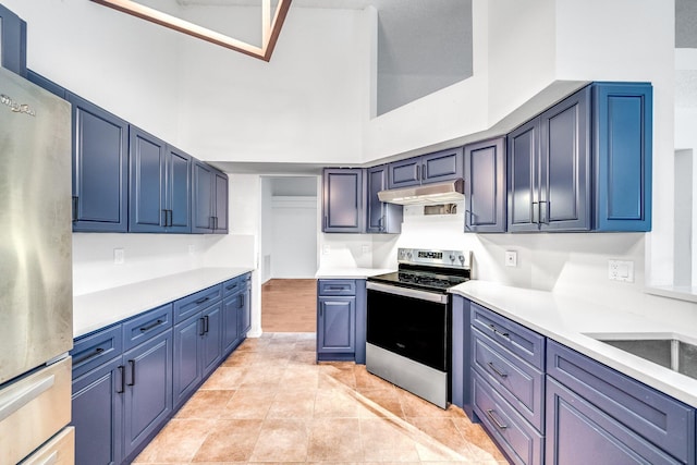 kitchen with stainless steel appliances, a high ceiling, light tile patterned floors, and blue cabinetry