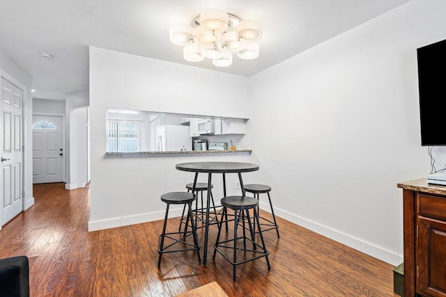 dining space featuring dark hardwood / wood-style floors and a chandelier