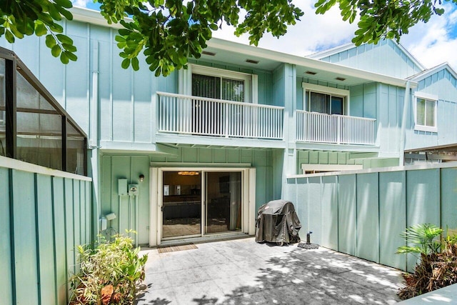 back of property featuring a balcony and a patio area