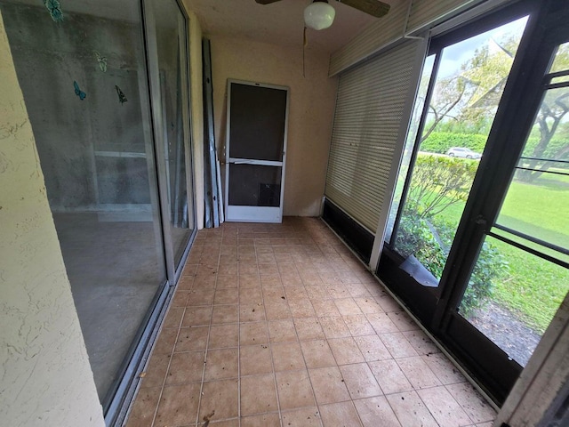 unfurnished sunroom featuring ceiling fan