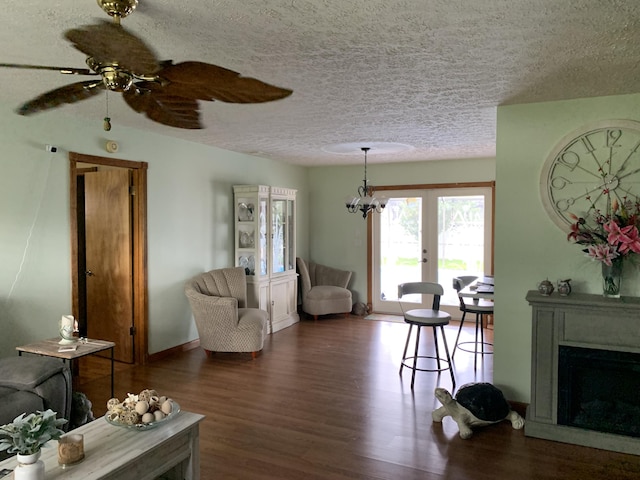 living room with a textured ceiling, dark hardwood / wood-style floors, and ceiling fan