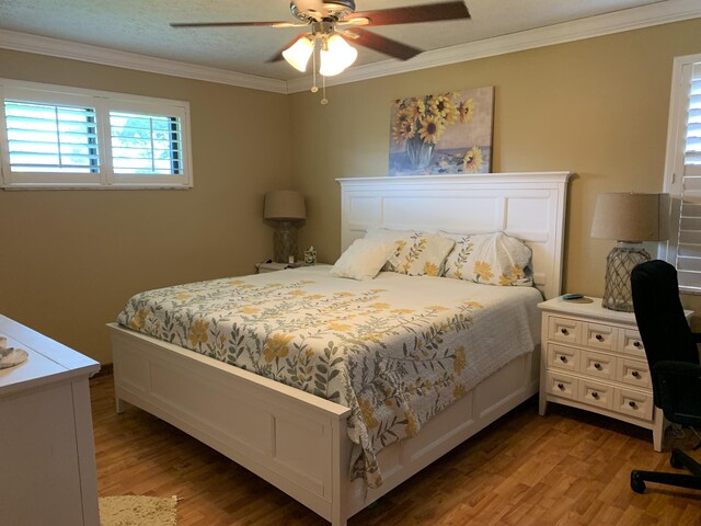 bedroom with ceiling fan, wood-type flooring, and ornamental molding