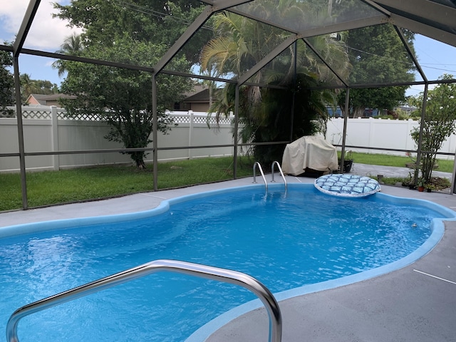 view of pool with a grill and a lanai