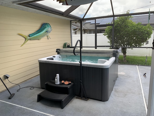 view of patio with a hot tub and a lanai