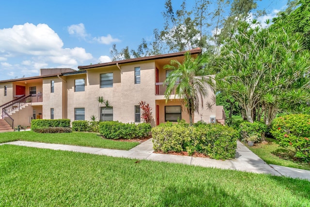 multi unit property featuring a front lawn and stucco siding