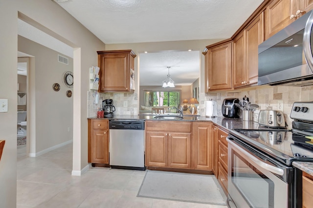 kitchen featuring light tile patterned flooring, tasteful backsplash, stainless steel appliances, pendant lighting, and sink