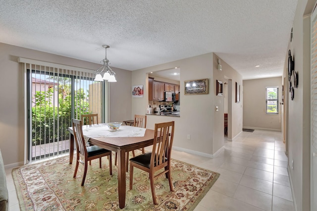 dining area featuring a textured ceiling and light tile patterned floors