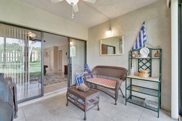 living area with light tile patterned floors and ceiling fan