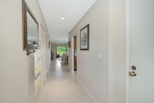 corridor with recessed lighting, light tile patterned flooring, and baseboards