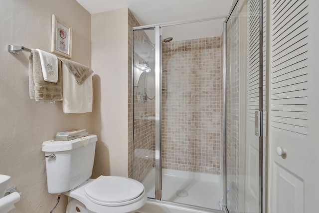 bathroom featuring toilet and an enclosed shower