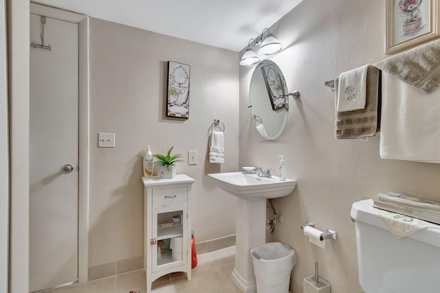 half bath featuring tile patterned flooring, baseboards, and toilet