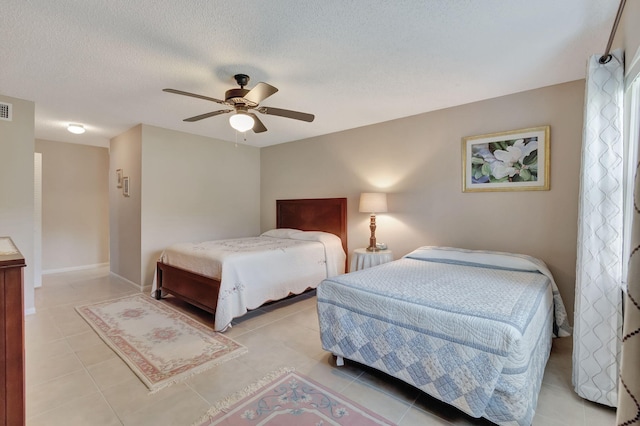 bedroom with baseboards, visible vents, ceiling fan, a textured ceiling, and light tile patterned flooring