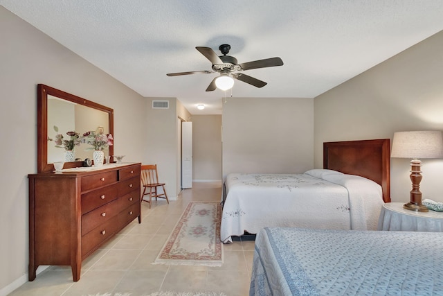 bedroom featuring light tile patterned floors, a textured ceiling, and ceiling fan