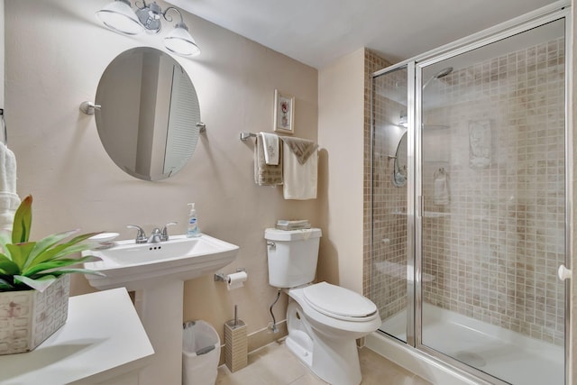 bathroom featuring toilet, tile patterned floors, and a shower with door