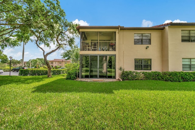 back of house featuring a lawn and stucco siding