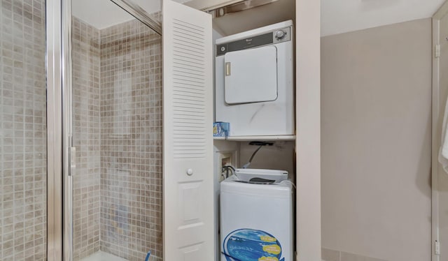 washroom with stacked washing maching and dryer and laundry area