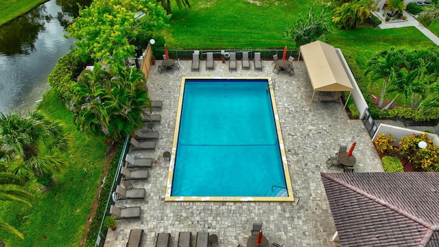 view of pool featuring a water view and a patio area