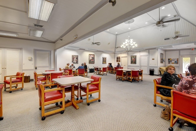 dining room featuring light carpet, ceiling fan with notable chandelier, and lofted ceiling