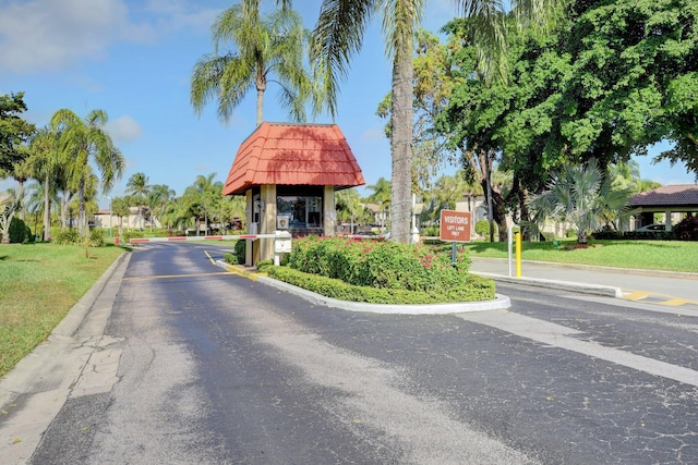 view of road with a gated entry and curbs