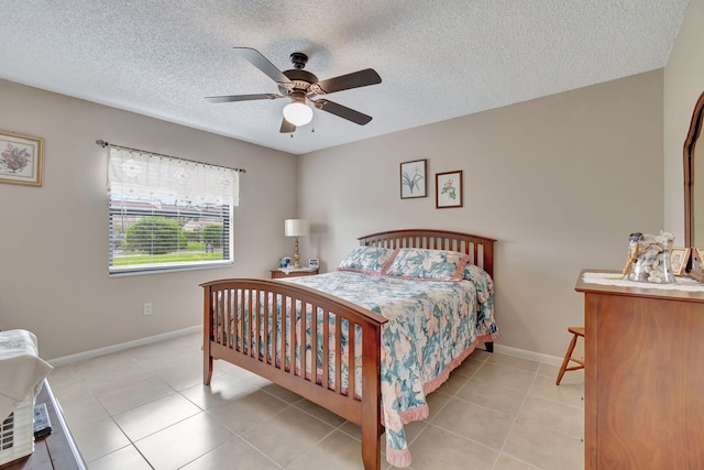 bedroom with light tile patterned flooring, a textured ceiling, and ceiling fan