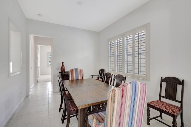 dining space with light tile patterned flooring, baseboards, and a healthy amount of sunlight