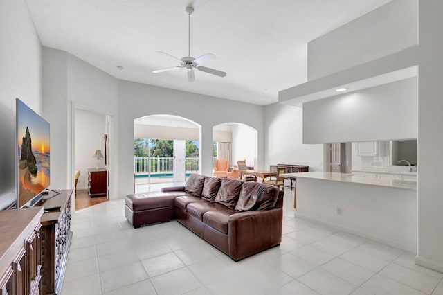 tiled living room featuring ceiling fan and sink