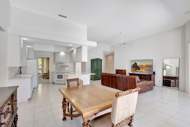 dining area featuring sink, ceiling fan, and light tile patterned flooring