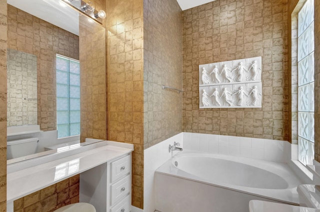 bathroom featuring vanity, a wealth of natural light, toilet, and a bathing tub