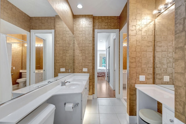 bathroom with vanity, tile walls, tile patterned floors, and toilet