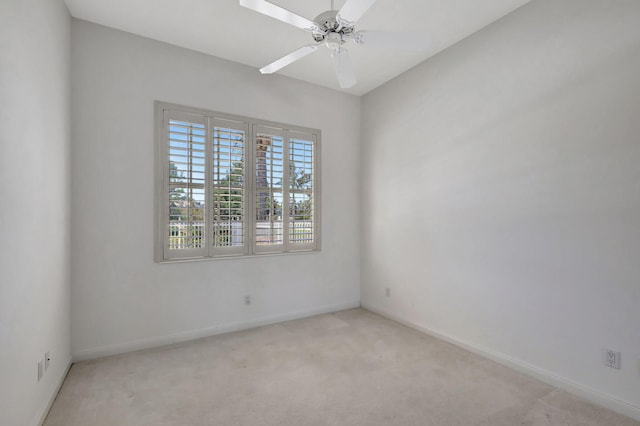 empty room with light colored carpet, ceiling fan, and baseboards