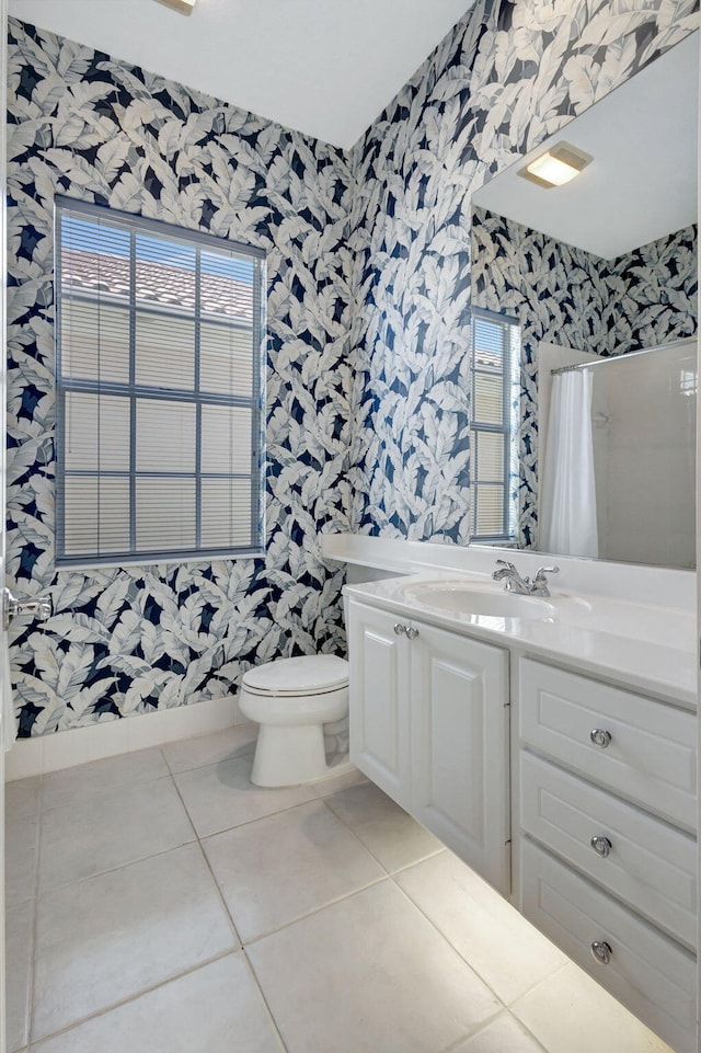 bathroom with a shower with shower curtain, vanity, a wealth of natural light, tile patterned floors, and toilet