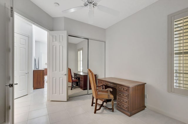office area featuring baseboards, ceiling fan, and light tile patterned floors