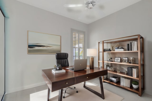 tiled home office featuring a ceiling fan and baseboards