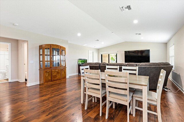 dining space with dark wood-type flooring and lofted ceiling