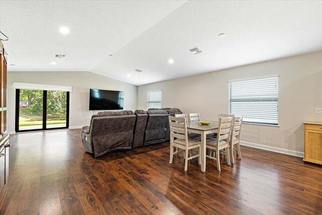 living room featuring dark hardwood / wood-style flooring, a textured ceiling, and vaulted ceiling