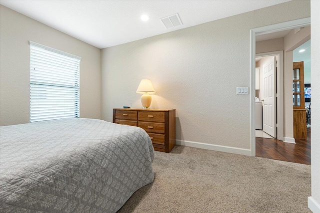 carpeted bedroom with washer and clothes dryer