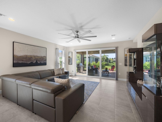 tiled living room with a textured ceiling and ceiling fan