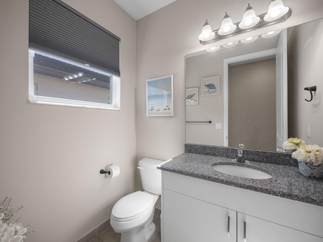 bathroom featuring tile patterned flooring, vanity, and toilet