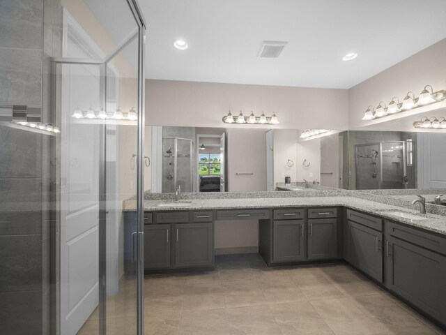 bathroom with tile patterned flooring, vanity, and walk in shower