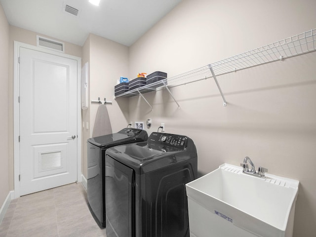 laundry room featuring washer and clothes dryer, sink, and light tile patterned floors