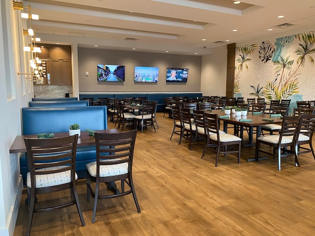 dining room with a tray ceiling and light hardwood / wood-style flooring