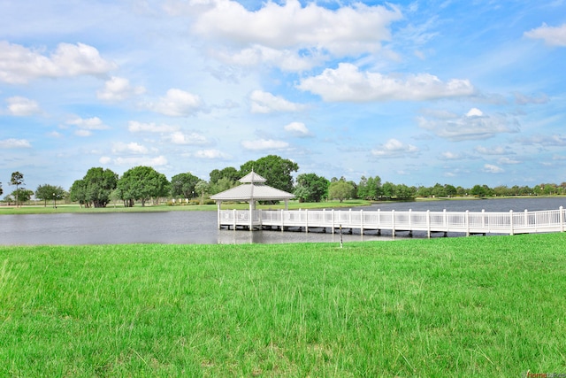 dock area with a gazebo, a lawn, and a water view