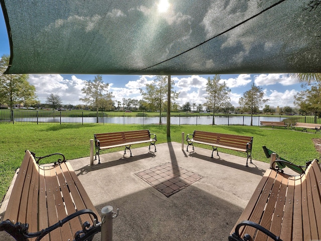 view of property's community with a yard, a patio area, and a water view