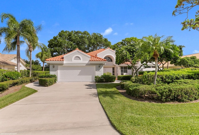 mediterranean / spanish home with a garage and a front yard