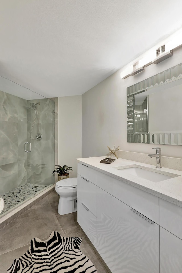 bathroom featuring toilet, vanity, and a shower with shower door