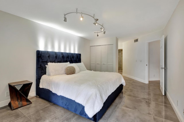 bedroom featuring rail lighting and a closet