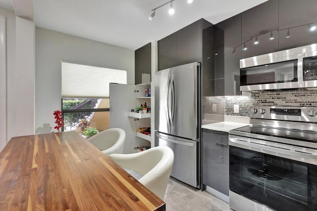 kitchen with butcher block counters, backsplash, and appliances with stainless steel finishes