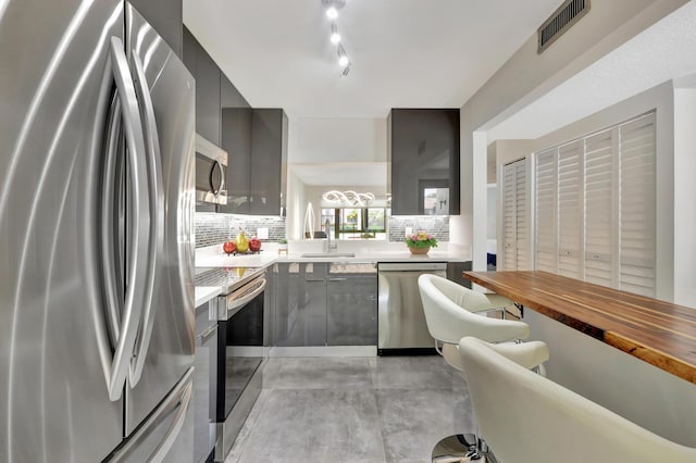 kitchen featuring stainless steel appliances, sink, and decorative backsplash